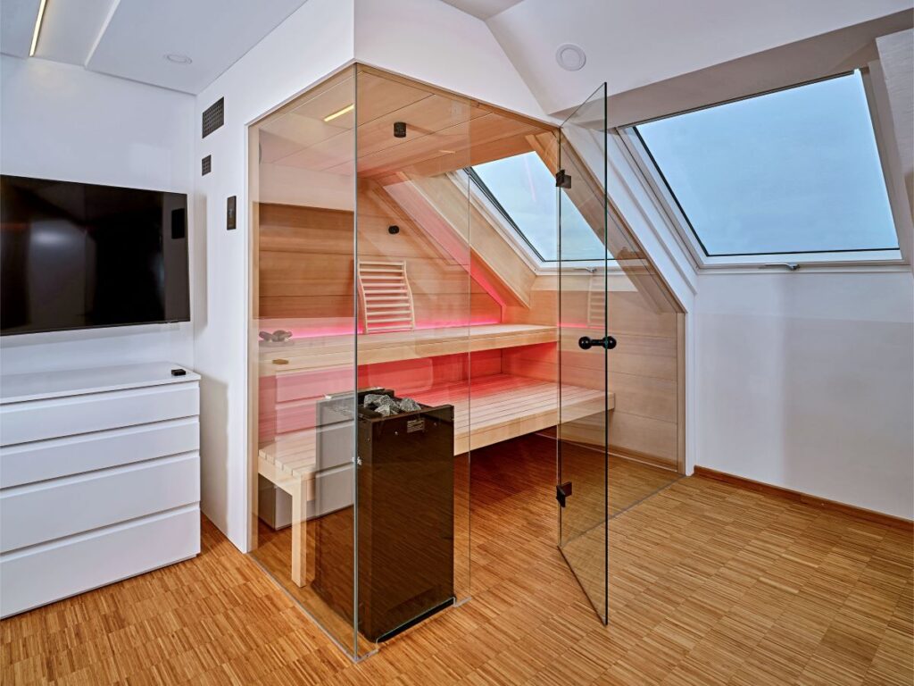 Feuchte Sauna unter Dachschräge mit Glasfront und hellem Holz in Wohnräumen