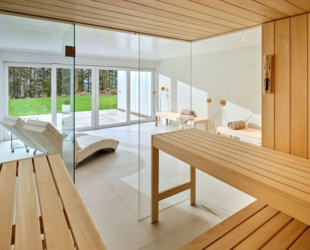 Kugel Sauna Elementsauna - helle Holzbänke mit Glasfront und Blick in den Garten