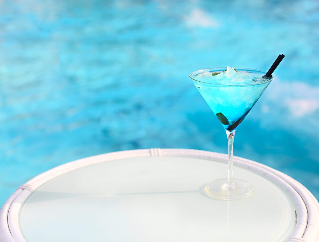 Exotischer Alkoholcocktail auf weißem Tisch am Pool
