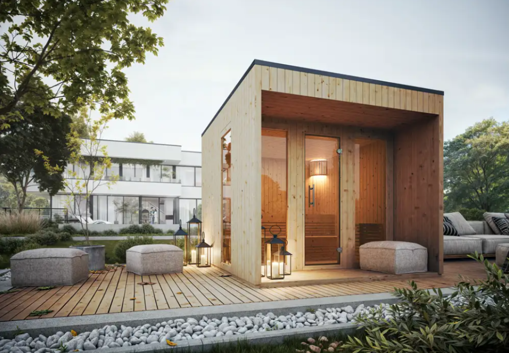 Gartenhaus mit Sauna. Die Gartensauna besticht durch klares, geometrisches Design. Helles Holz und hohe Fenster sorgen für Lichteinfall. Eine anliegende Terrasse macht grenzt daran an.