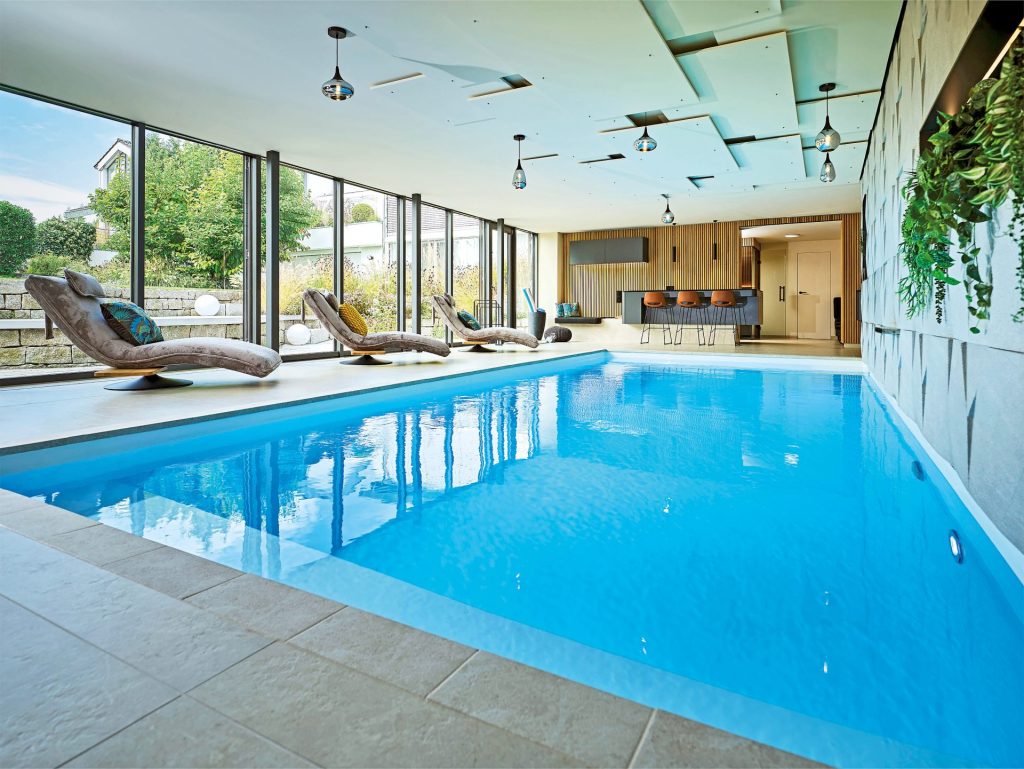 Beste Aussichten: Von der edlen und großzügigen Poollandschaft aus fällt
der Blick in den liebevoll angelegten Garten. Bei Dunkelheit lässt sich dieser, ebenso wie das Becken, beleuchten.