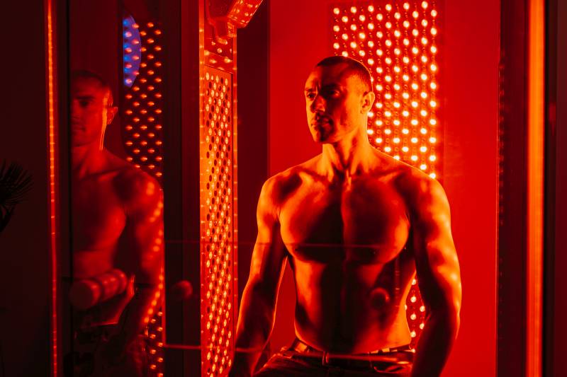 Muskulöser Mann vor Infrarotstrahler