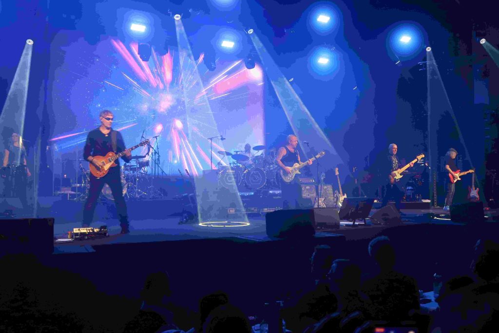 Die Rockband liefert eine Show auf der Bühne und das Publikum feiert.