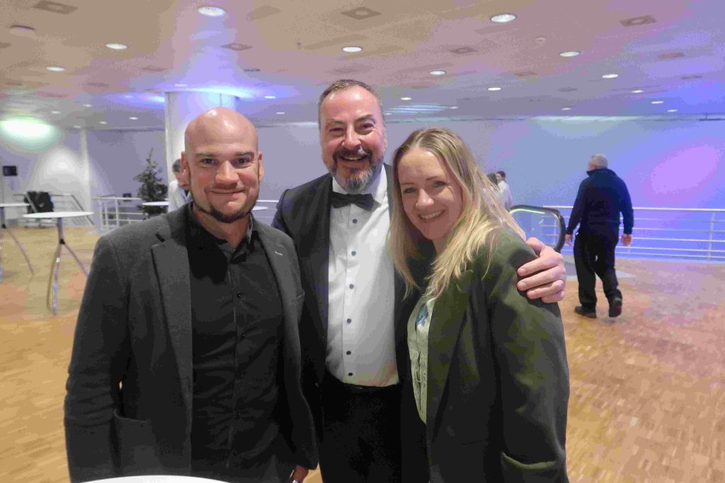 Zwei Männer und eine Frau im Congresscentrum am Abend.