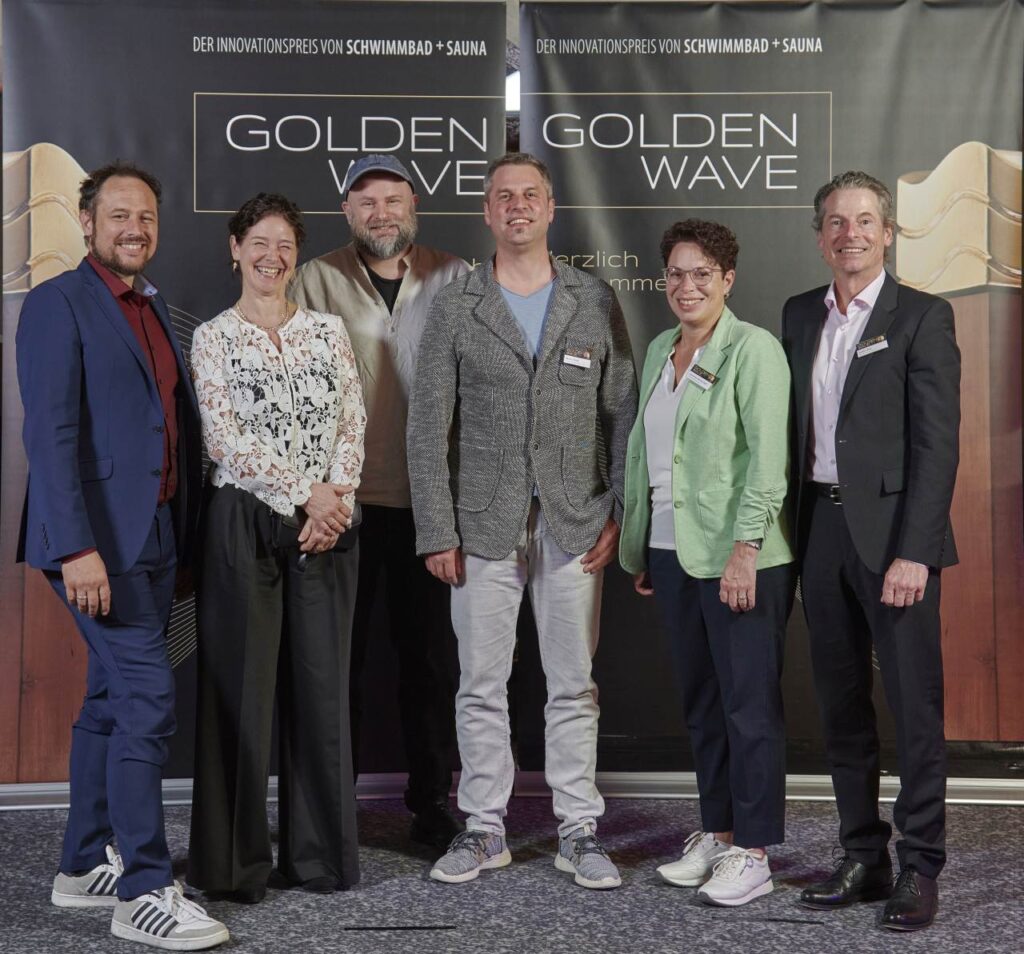 Gruppenbild der Jury vor der Golden Wave Fotowand.