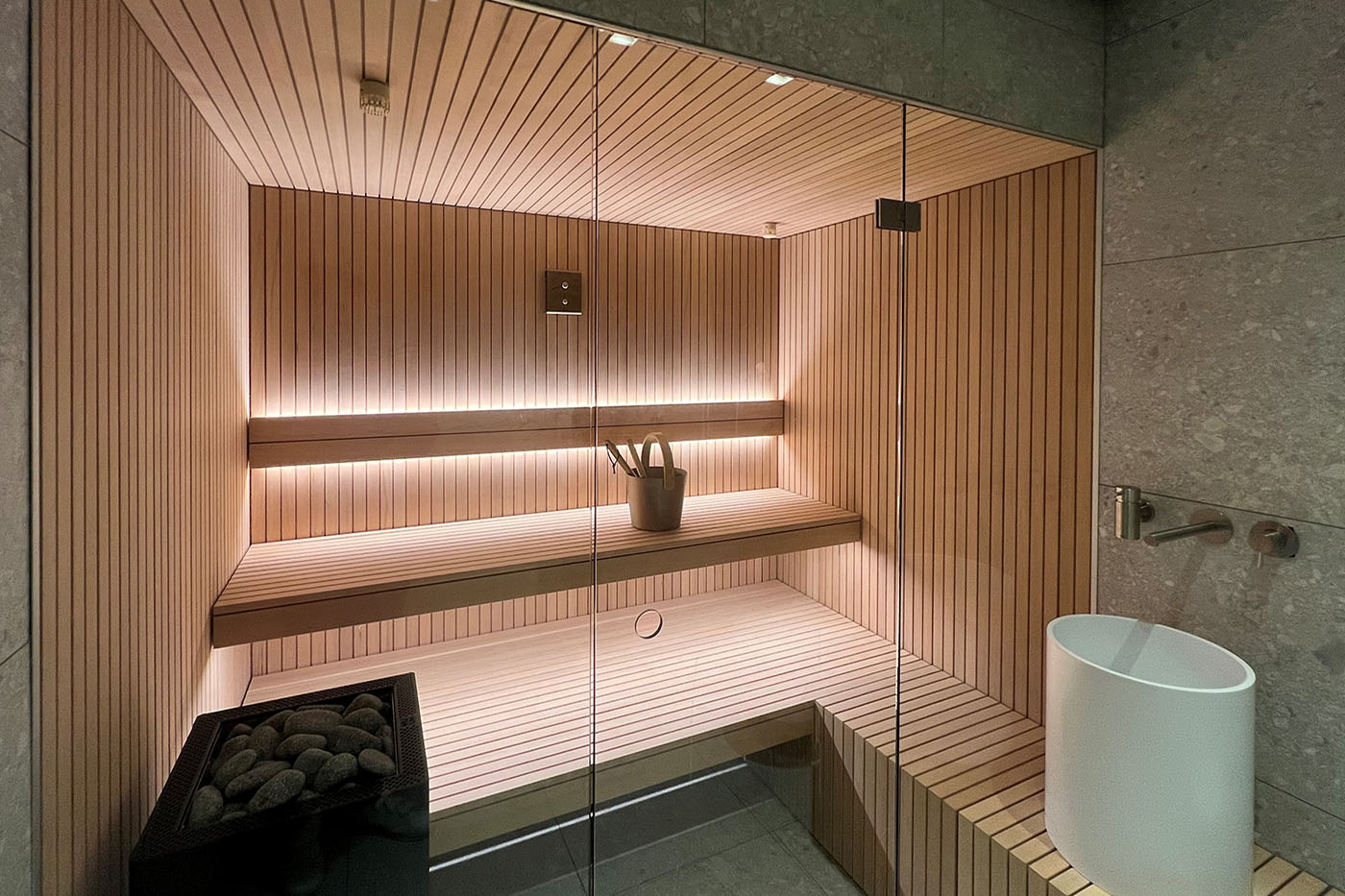 Sauna aus in Stäbchenoptik aus Holz mit Glasfront 