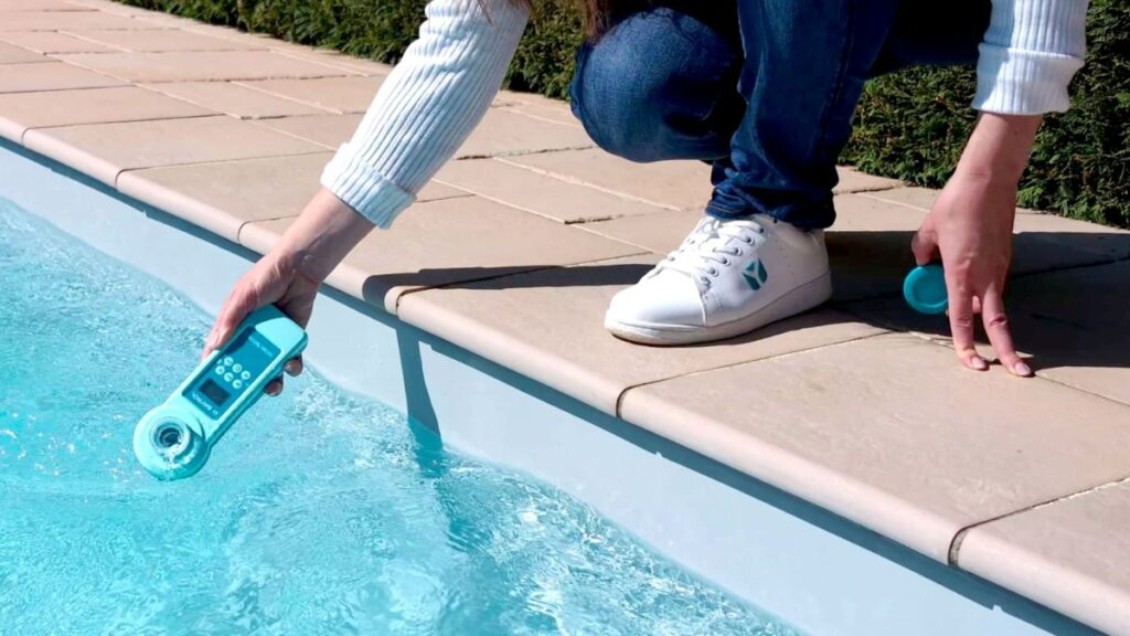 Person prüft Poolwasser mit Elektronischem Pooltester II BAYROL