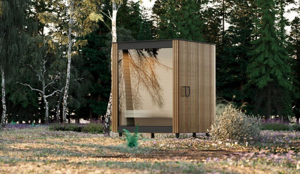 Die Sauna im Außenraum hat eine Holzfassade und eine Glastür.
